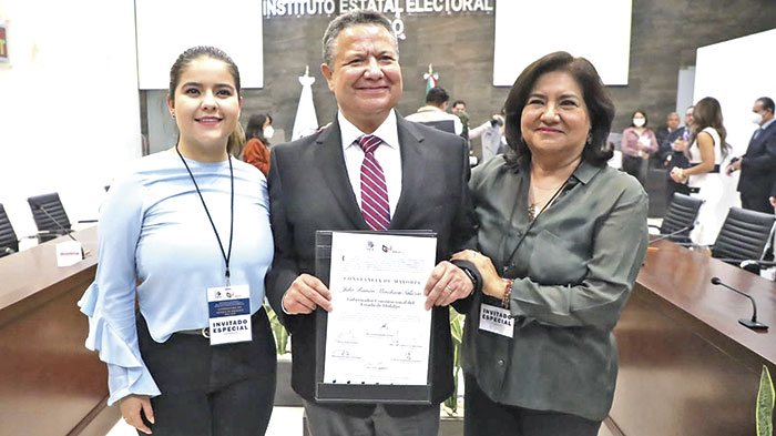 Julio Menchaca Salazar tras recibir la constancia de mayoría que lo acredita como gobernador electo. Lo acompañan su esposa e hija, en la ceremonia que se realizó en el Instituto Estatal Electoral de Hidalgo para la entrega de la declaratoria como ganador de la elección del pasado domingo 5 de junio.